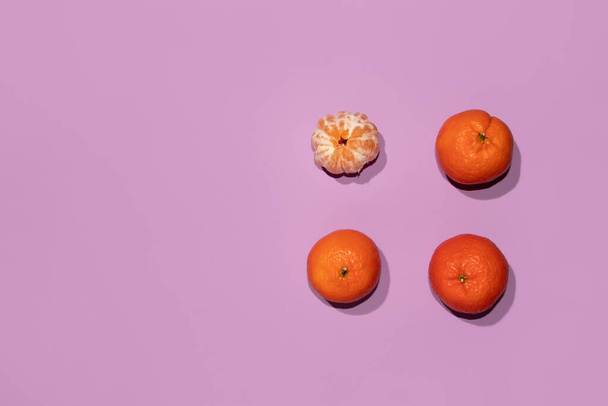 Tangerines on a light purple background. Minimal concept. Fruit flat lay. - 写真・画像