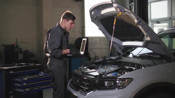 обслуговування машини, молодий чоловік-спеціаліст з ноутбуком в руках діагностичний автомобіль на технічній станції
 - Кадри, відео