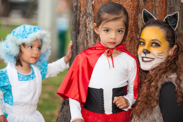 Настоящая семья веселится в костюмах из сказки "Маленький красный капот" на Хэллоуин. - Фото, изображение