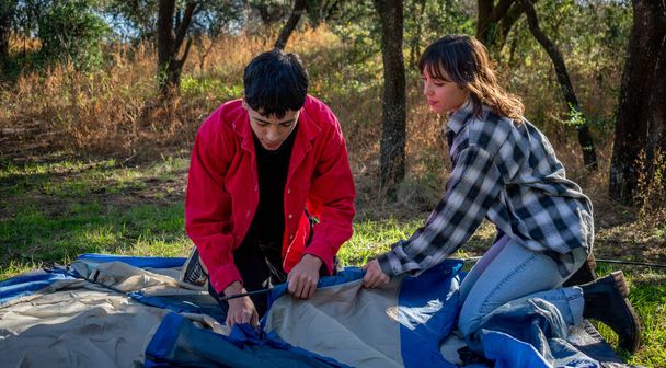 two friends pitch a tent at the campsite - Foto, Imagen