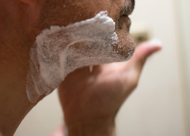 Sluiten van onherkenbare volwassen man scheren zijn gezicht - Foto, afbeelding