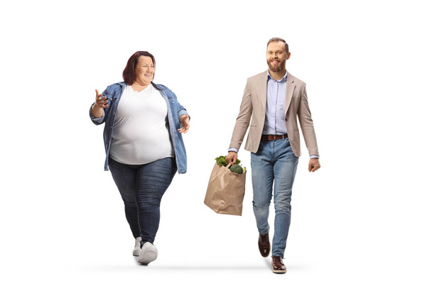 Corpulent woman and a man with grocery bags walking and having a conversation isolated on white background - Foto, Bild
