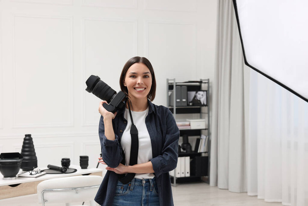 Young professional photographer with camera in modern photo studio - Fotografie, Obrázek