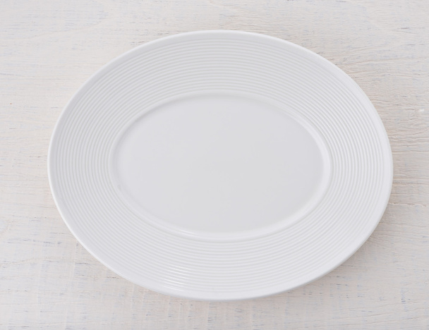 Tahta masaya boş beyaz seramik tabak - Fotoğraf, Görsel