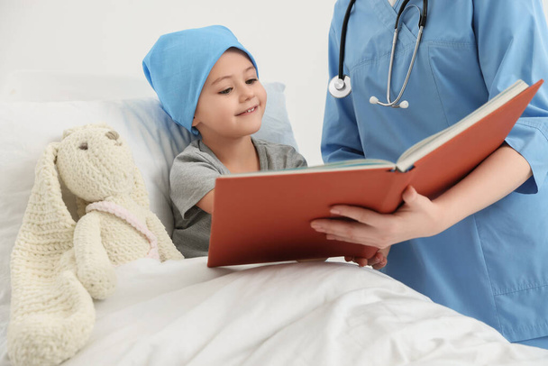 Childhood cancer. Doctor and patient reading book in hospital - Valokuva, kuva