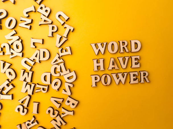 Juguete de letras de madera arreglado la palabra WORD Have POWER con un fondo amarillo. - Foto, Imagen