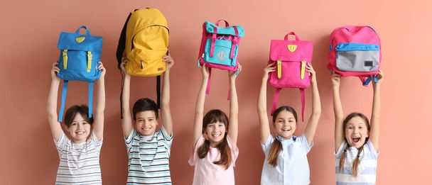 Many little students with schoolbags on beige background - Foto, Imagem