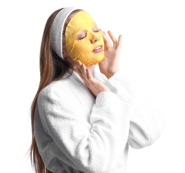 Young woman in bathrobe with turmeric mask on white background - Fotó, kép