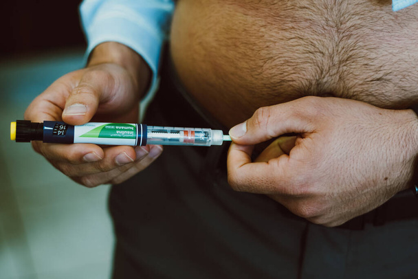 June 27, 2023, Brazil. In this photo, a man injects human insulin into the body for blood glucose control - Photo, image
