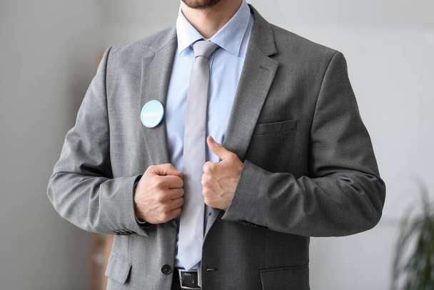 Мужчина-волонтер со значком в офисе, крупный план - Фото, изображение
