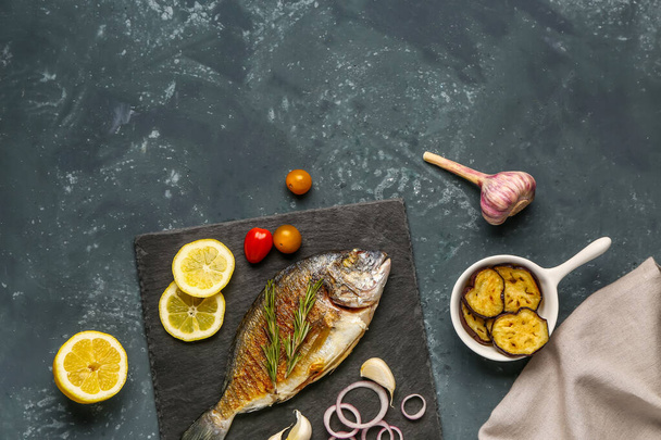 Сланцева дошка зі смачною рибою дорадо на сірому фоні - Фото, зображення