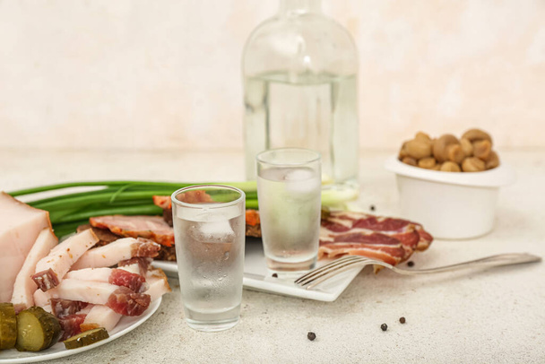 Shots with cold vodka and snacks on light background - Photo, Image