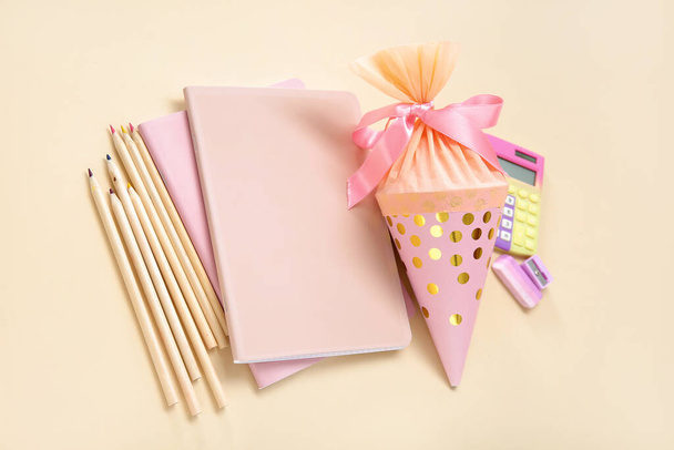 Pink school cone with different stationery on pale orange background - Photo, Image