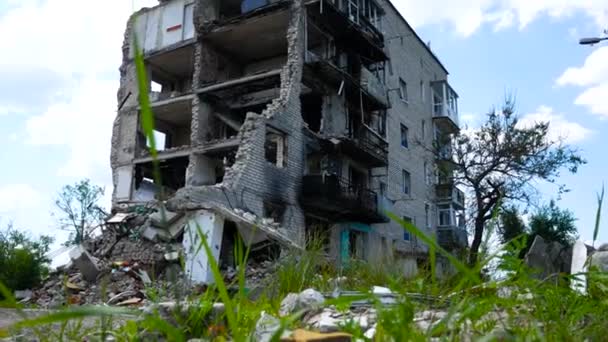 Ukrayna 'nın bir şehrinde hava saldırısıyla yıkılan çok katlı bir bina. Evin girişi tahrip edilmiş, duvarları olmayan bir levye, duvarlarda ateş izleri. Russo-Ukrayna Savaşı - Video, Çekim