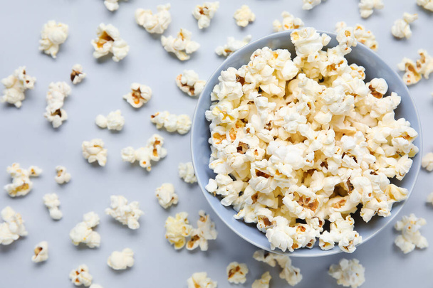 Schüssel mit leckerem Popcorn auf grauem Hintergrund - Foto, Bild