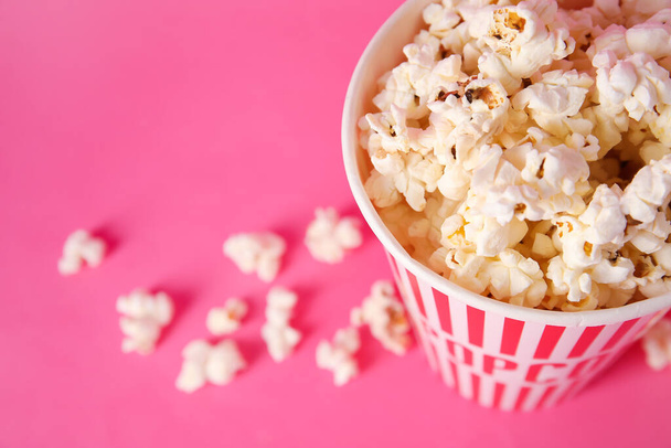 Ämpäri maukkaita popcornia vaaleanpunainen tausta - Valokuva, kuva