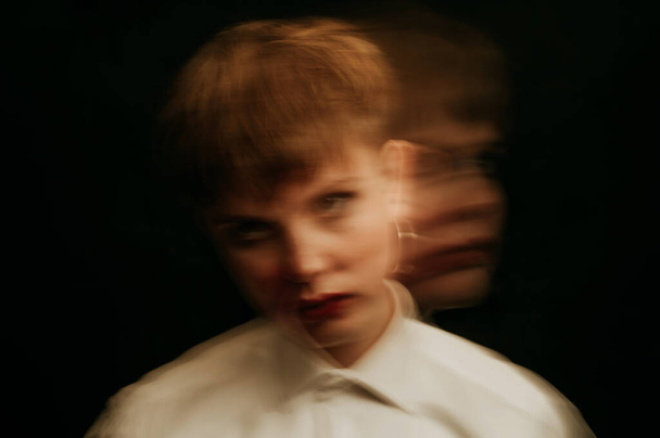 psychopath with mental disorders and insanity on a dark background. A blurry portrait of a woman in a straitjacket - Zdjęcie, obraz