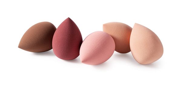 Una esponja de maquillaje en forma de huevo colocada sobre un fondo blanco.  - Foto, imagen