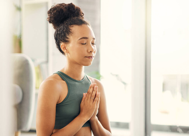 Προσεύχονται τα χέρια, χαλαρώστε και διαλογισμό από τη γυναίκα σε ένα σαλόνι για την ειρήνη, την ευεξία ή την ψυχική υγεία ισορροπία στο σπίτι. Προσευχή στάση, γιόγκα και κυρία διαλογίζονται στο σαλόνι για zen, επούλωση ή ολιστική άσκηση. - Φωτογραφία, εικόνα