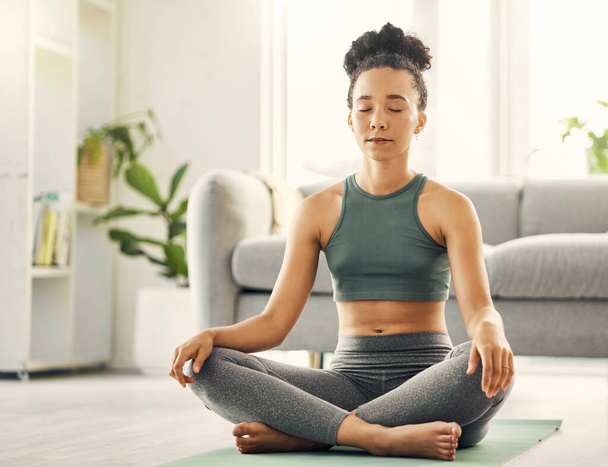 Meditation, woman and lotus pose on living room floor for peace, mental health and wellness at home. Yoga, breathing and exercise by female meditating in a lounge for zen, holistic or chakra training. - Photo, Image