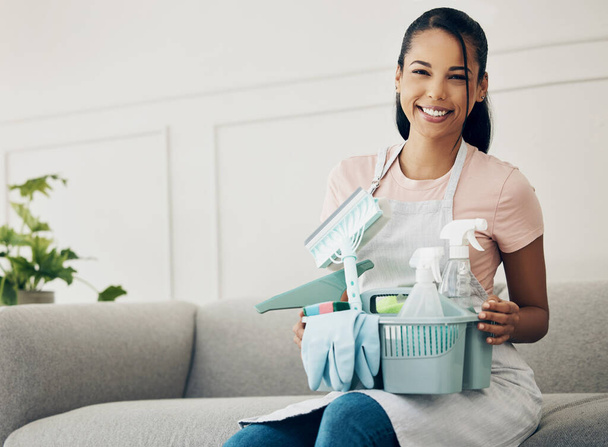 Woman, cleaning tools and smile in portrait, chemical spray and hygiene with household maintenance product. Happy female cleaner, janitor supplies in basket and clean house, service and detergent. - Фото, зображення