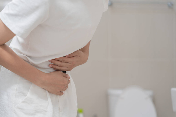 Constipation and diarrhea in bathroom. Hurt woman touch belly  stomach ache painful. colon inflammation problem, toxic food, abdominal pain, abdomen, constipated in toilet, stomachache, Hygiene - Photo, image