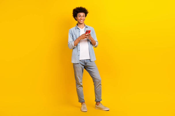 Full size portrait of handsome man hold use smart phone chatting isolated on yellow color background. - Φωτογραφία, εικόνα