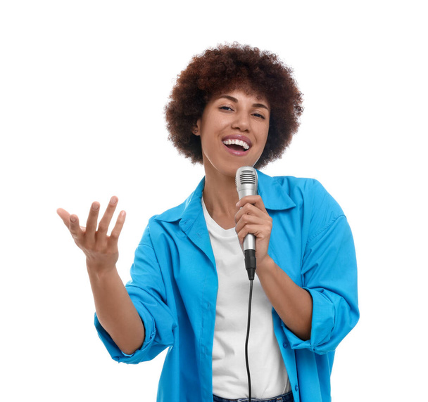 Curly young woman with microphone singing on white background - Valokuva, kuva