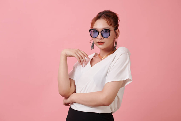 Retrato de estudio de mujer transgénero de moda en blusa blanca y gafas de sol - Foto, Imagen