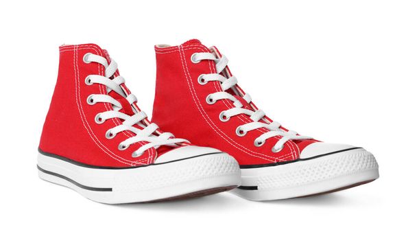 Pair of new red stylish high top plimsolls on white background - Foto, afbeelding
