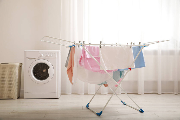 Clean laundry hanging on drying rack indoors - Photo, image