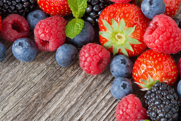 деревянный фон со свежими ягодами и мятой, горизонтальный
 - Фото, изображение