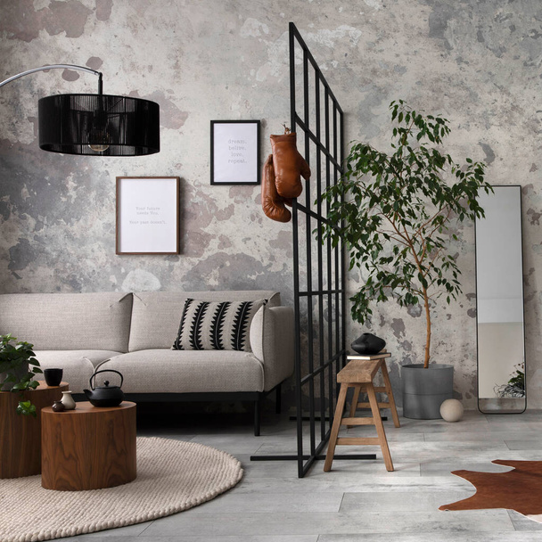 Exquisite and modern composition of living room interior with design grey sofa, bench, plant, brown coffee tables, decoration, pillow and elegant accessories. Concrete grunge wall. Template. - Fotografie, Obrázek