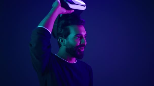 Hombre árabe quitarse gafas VR sonrisa emocionada sorprendido con metaverso realidad virtual ciberespacio chico indio con gafas 3d casco feliz wow reacción después de jugar juego meta universo neón ultravioleta espacio - Imágenes, Vídeo