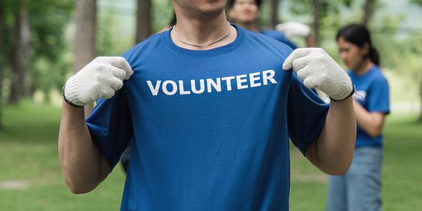 Zblízka mladý muž dobrovolník na sobě tričko s dobrovolnou zprávou. - Fotografie, Obrázek