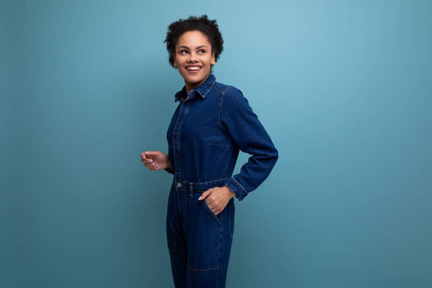 hübsche brünette lateinamerikanische Frau in blauem Jeansanzug über isoliertem Hintergrund. - Foto, Bild