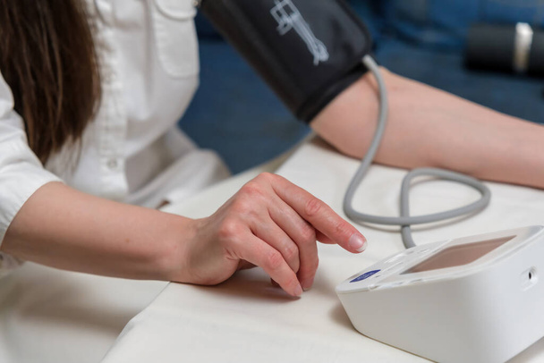 woman measures blood pressure. arterial hypotension. hand and tonometer close-up. - Foto, Bild