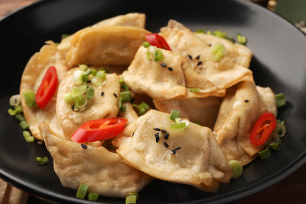 Delicious gyoza (asian dumplings) with sesame seeds, green onions and chili peppers in bowl, closeup - Φωτογραφία, εικόνα