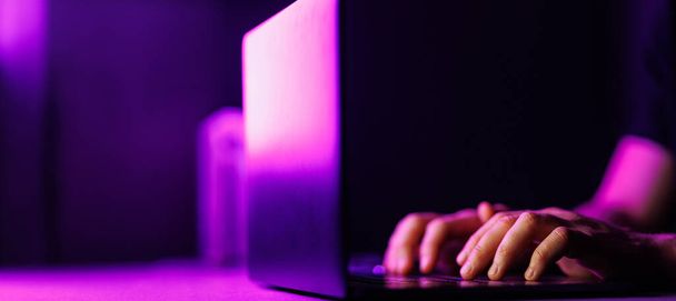 Man handen en laptop op moderne paarse kleur omgeving. Kopieer ruimte op zwarte achtergrond. Hoge kwaliteit foto - Foto, afbeelding