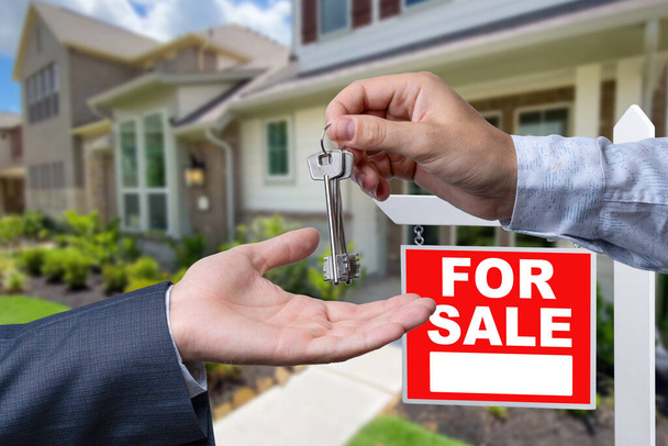 Agent nieruchomości przekazujący klucze do domu przed pięknym nowym domem i na sprzedaż Zarejestruj nieruchomości - Zdjęcie, obraz