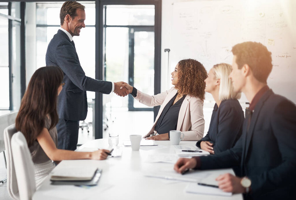 オフィスでの会議でのチームワーク、合意またはパートナーシップのためのビジネスマン、握手と会議。女性と握手をするビジネスマンb2b,企業の成長や職場での雇用. - 写真・画像