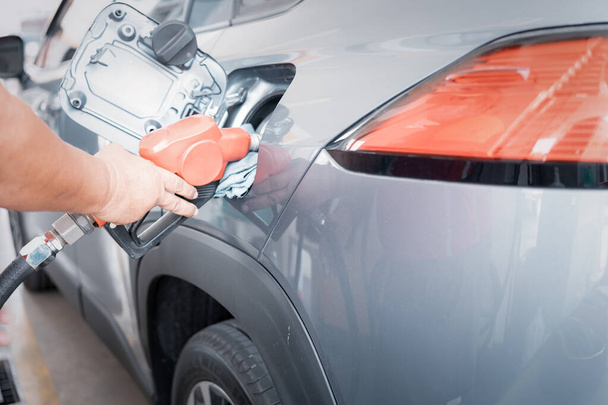 Man handle pumping gasoline fuel nozzle to refuel at petrol station. Transportation and ownership concept. - Photo, image