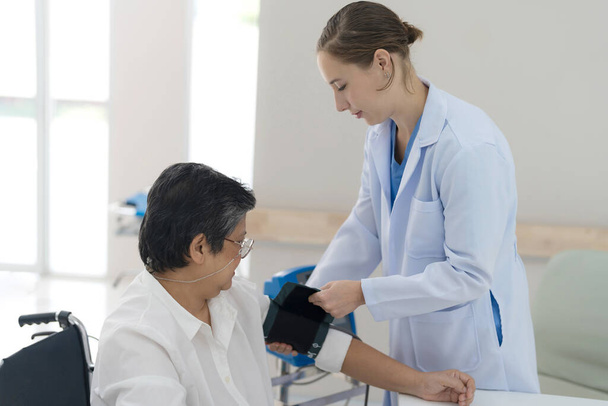 Літня жінка перевіряє артеріальний тиск для перевірки здоров'я організму лікарем за порадою
. - Фото, зображення