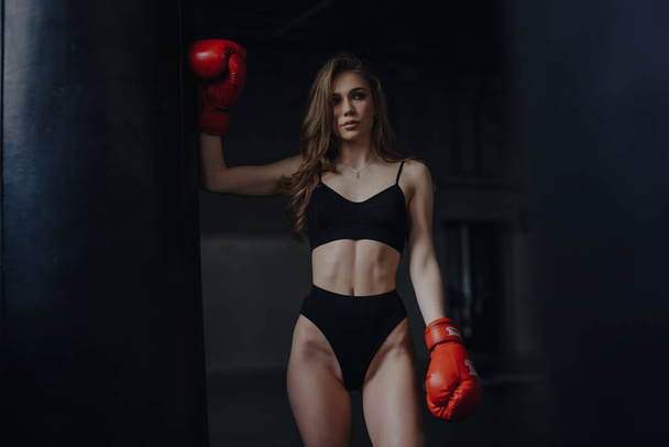 Sexy woman boxer in bra and panties posing at the box club - Photo, Image