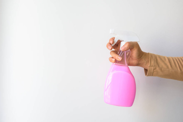 Woman hand-holding pink hygiene spray bottle. Isolated on a white background with copy space. - Photo, Image