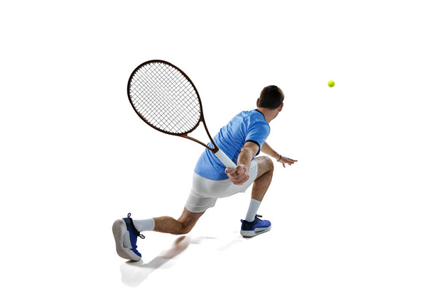 Championship. Professional male tennis player in motion during game, match serving ball isolated over white background. Concept of sport, active lifestyle, game, hobby, health, dynamics, ad - Φωτογραφία, εικόνα
