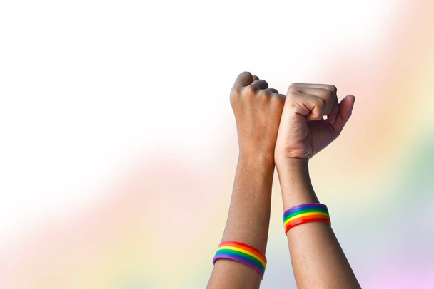 Kezek, amelyek szivárvány karszalagok körül, LMBT szimbólum, koncepció LMBT ünneplés büszkeség hónap júniusban szerte a világon. - Fotó, kép