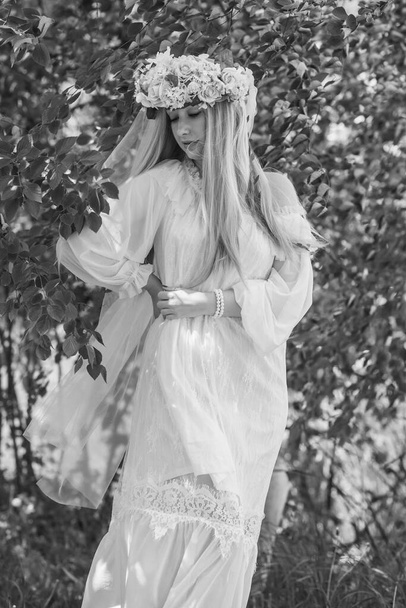 Europäisch-slawische Tradition, Braut im weißen Kleid, Blumenkranz mit Schleier auf dem Kopf. Zartes Mädchen - Foto, Bild