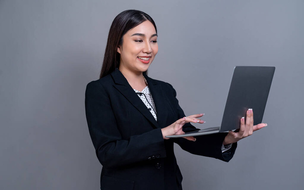Jovem empresária asiática confiante posando com laptop em fundo isolado. Escritório senhora fazer mão segurando gesto para promoções de vendas, anúncios de tecnologia ou imagem de recrutamento de RH. Jubilante - Foto, Imagem