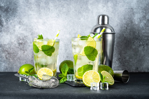 Mojito with rum and lime on black background. Traditional Summer drink with ice. - Photo, image